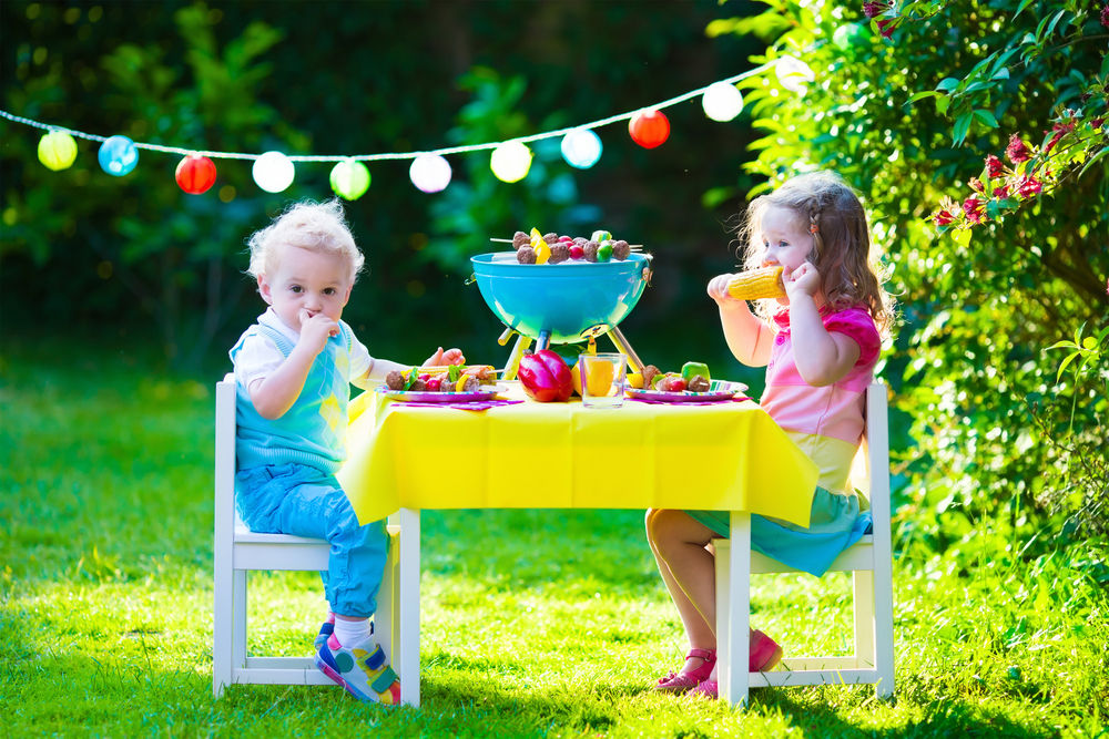 Vasos de papel de colores, servilletas y platos en la mesa de la fiesta que  mejoran la celebración de cumpleaños de los niños